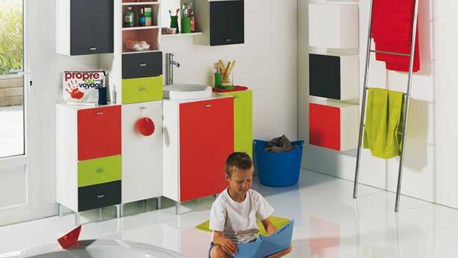 Baie pentru copii alba cu pardoseala epoxidica lucioasa si cu mobilier cu usi si sertare colorate in rosu verde si negru