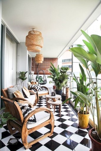 Balcon deschis cu pardoseala alb-negru in carouri mobilier din lemn si plante decorative in ghiveci