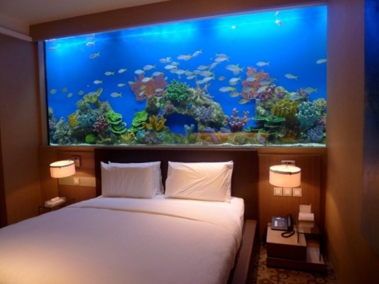 Dormitor opulent cu acvariu pe peretele de deasupra patului