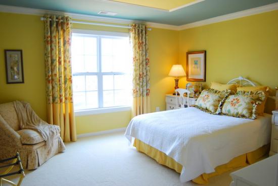 Dormitor cu draperie galbena cu model floral