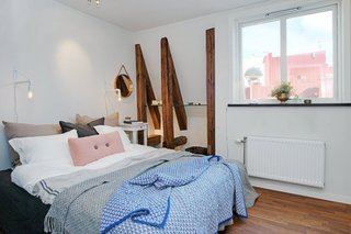 Dormitor amenajat cu parchet din lemn masiv si etajera din sticla si barne din lemn