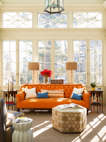Living cu ferestre mari cu rama alba si canapea portocalie 