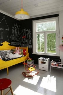 Camera de copii cu pereti cu vopsea cu efect de tabla de scris si canapea galbena