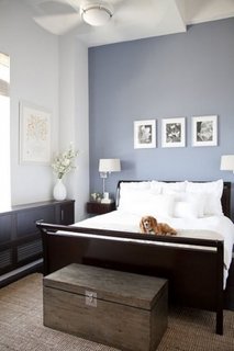 Dormitor cu pereti gri albastrui si mobilier maro inchis
