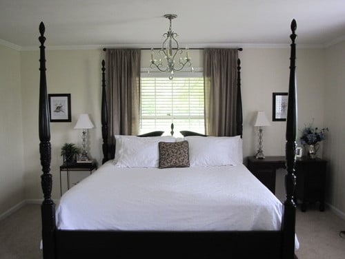 Dormitor mic amenajat cu pat pe mijloc si jaluzele albe cu perdele crem inchis