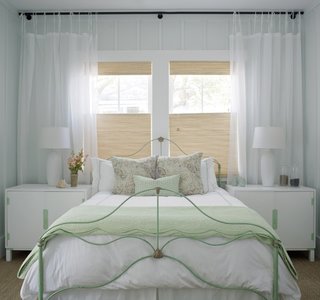 Mobila alba pentru un dormitor mic cu jaluzele partiale din paie si perdele albe din voal transparen