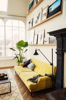 Canapea galbena pentru o pata de culoare intr-un interior incarcat de arta