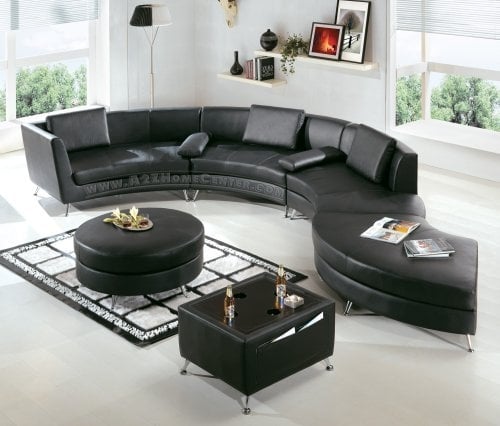 Canapea pe curb din piele neagra intr-un living monocromatic
