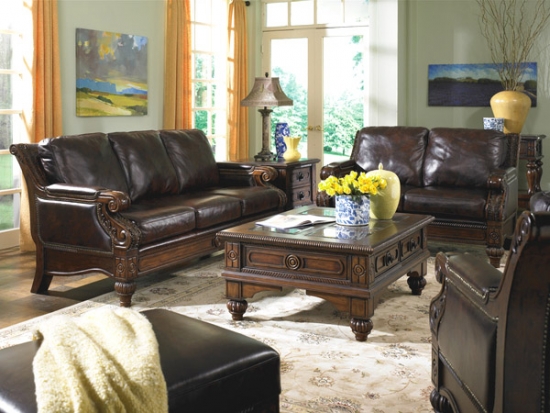 Living mobilat clasic cu canapea si fotolii din piele de culoare inchisa