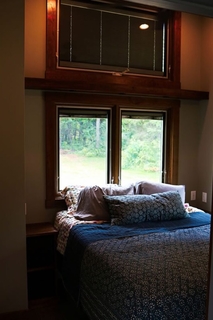 Dormitor mic cu patul langa fereastra