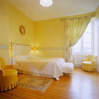 Dormitor romantic galben cu pat alb pe mijloc