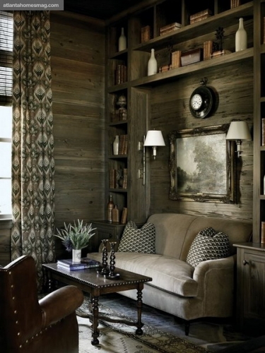 Living amenajat in stil rustic cu biblioteca pe peretele din spatele canapelei