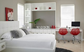 Dormitor alb cu accente decorative rosii si spatiu de lucru