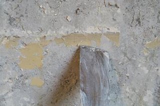 Curatarea cu spaclul a peretilor afectati de mucegai