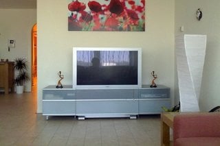 Tablou colorat pe perete deasupra televizorului