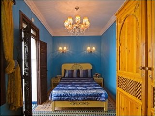 Dormitor cu mobila din lemn galbui si zugraveala albastra