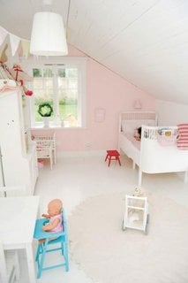 Camera pentru fetita amenajata la mansarda cu mobilier alb si peretii roz pal