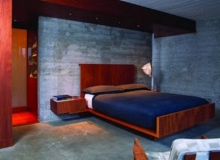 Dormitor cu finisaje industriale si pat pe mijloc cu doua noptiere