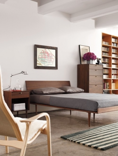 Dormitor simplu si practic cu pat si comoda inalta si biblioteca incorporata in perete