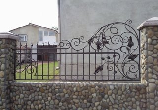 Gard placat cu piatra si elemente din fier forjat