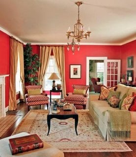 Living amenajat in stil clasic cu canapea crem si peretii rosii