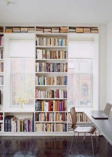 Biblioteca construita pe intreg peretele in jurul ferestrelor