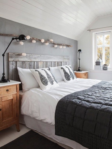 Dormitor cu noptiera din lemn si ghirlanda de LED-uri deasupra patului
