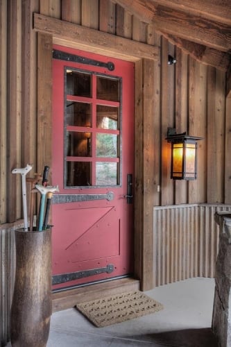 Usa din lemn vopsit maro rosiatic la o casa placata cu lemn