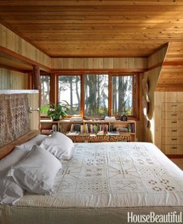 Pat alb in dormitor amenajat cu lemn 