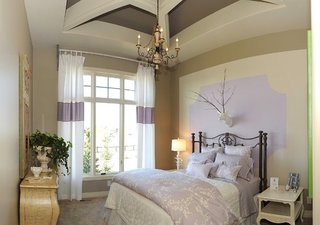 Dormitor clasic zugravit in crem si accente lila si pat din fier forjat