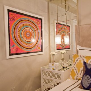 Tablou abstract in culori tari intr-un dormitor mic cu oglinzi