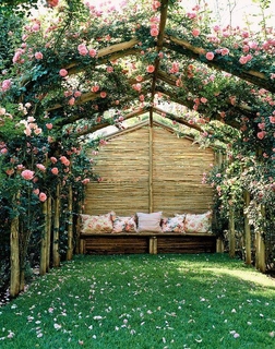Arcada rustica din lemn acoperita cu trandafiri cataratori